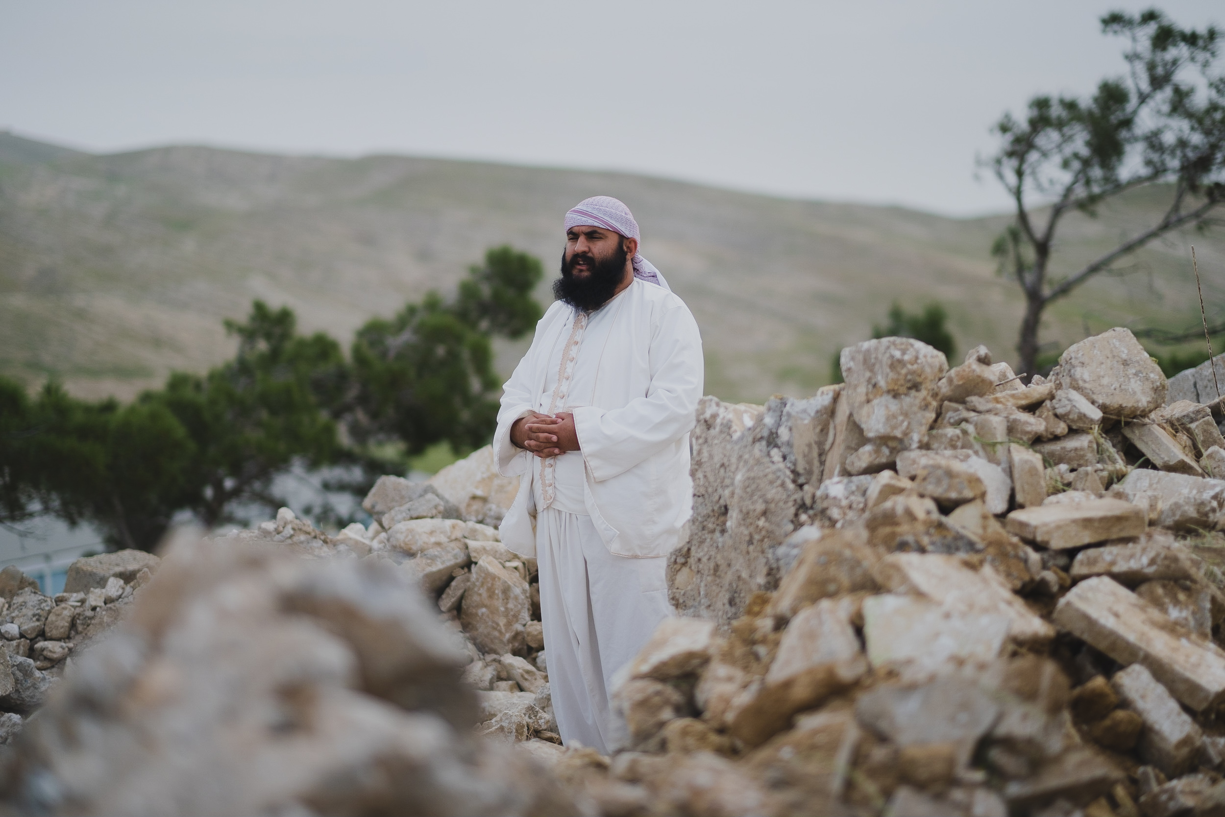 Mam Fakher, a religious man in Shingal, makes a prayer at the Shrine of Ma’awi after its destruction by the Islamic State.(Photo: Kurdistan 24/Levi Clancy)