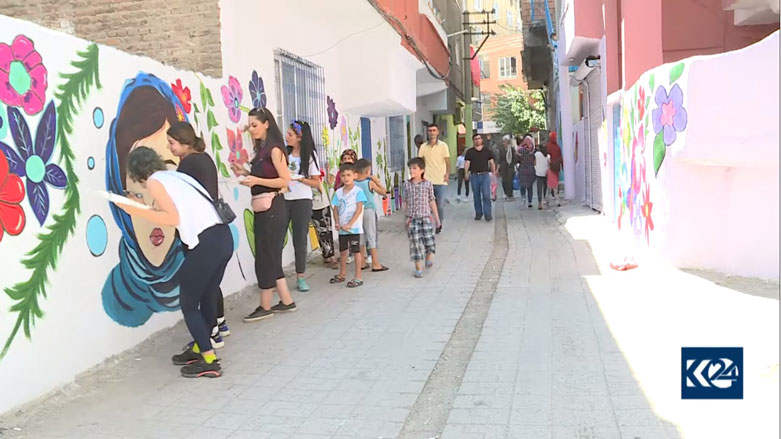 Jineke xêzkar kuçeyên Diyarbekirê dixemilîne