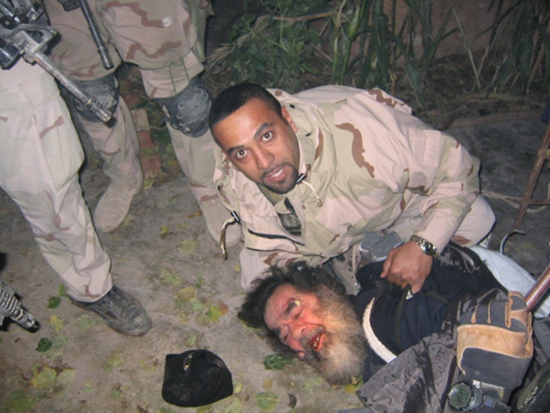Iraqi-American, Samir, 34, pinning deposed Iraqi leader Saddam Hussein to the ground during his capture in Tikrit, on Saturday, December 13, 2003. (Photo: US Army)