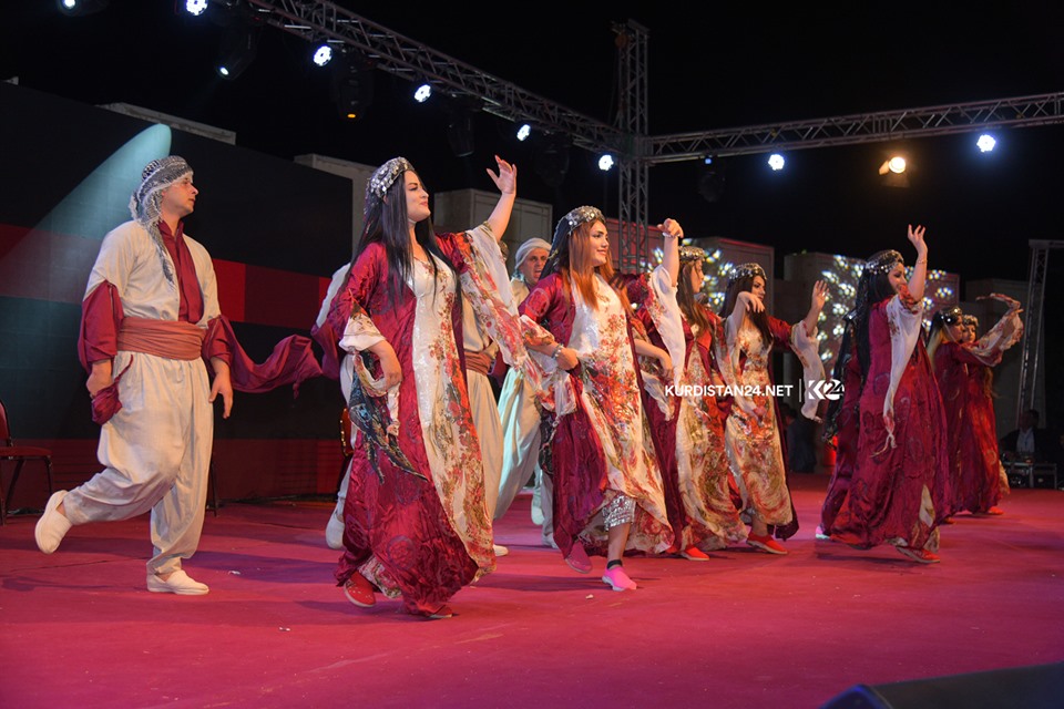 A group of dancers wearing traditional attire performing on stage in the Kurdistan Region city of Rania during a cultural exchange event, Sept. 19, 2019. (Photo: Kurdistan 24/Ismael Shamzini)