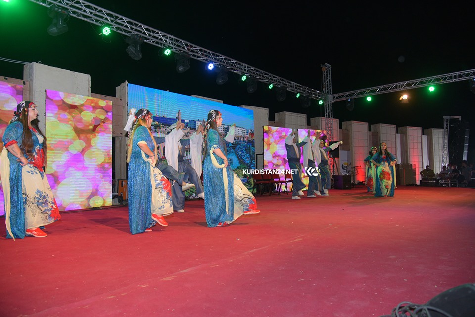 A group of dancers wearing traditional attire performing on stage in the Kurdistan Region city of Rania during a cultural exchange event, Sept. 19, 2019. (Photo: Kurdistan 24/Ismael Shamzini)