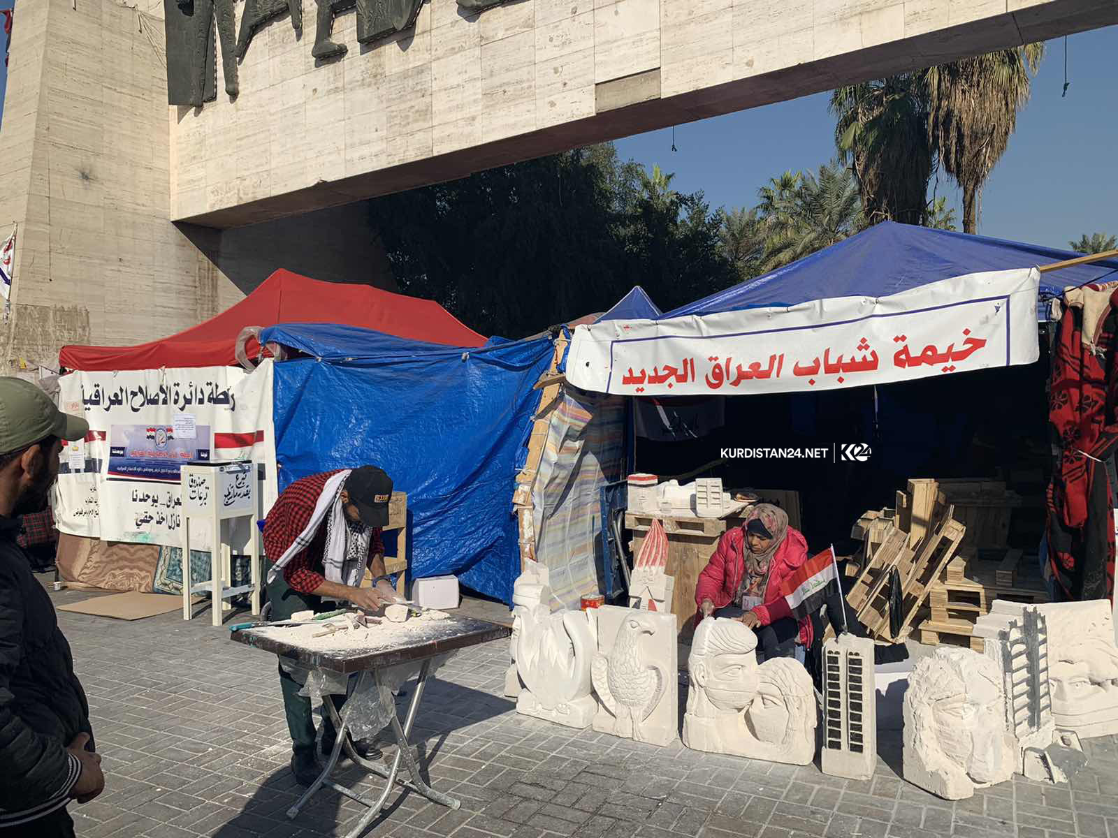 خۆپیشاندەرێك لە بەغدا لۆگۆی كوردستان24 دەنەخشێنێ