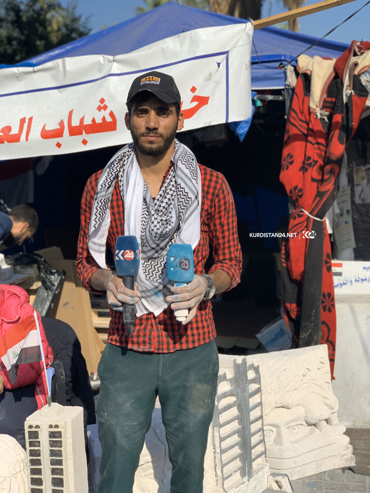 خۆپیشاندەرێك لە بەغدا لۆگۆی كوردستان24 دەنەخشێنێ