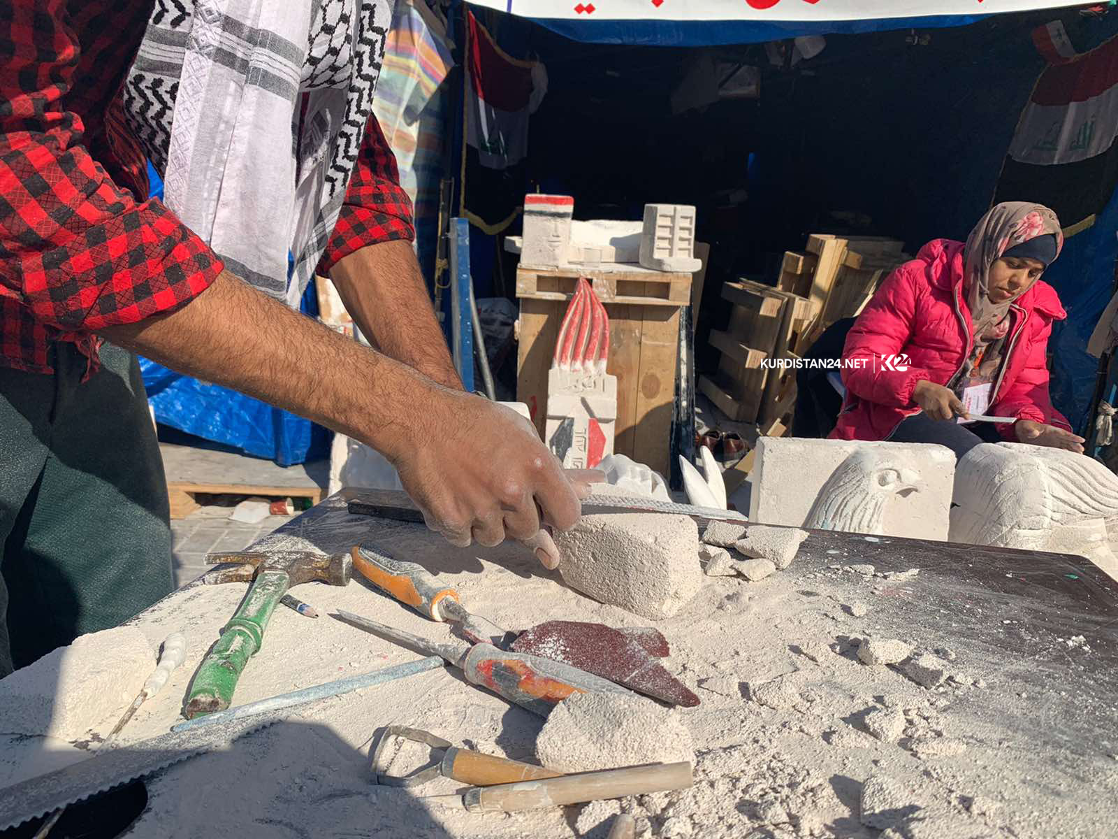خۆپیشاندەرێك لە بەغدا لۆگۆی كوردستان24 دەنەخشێنێ