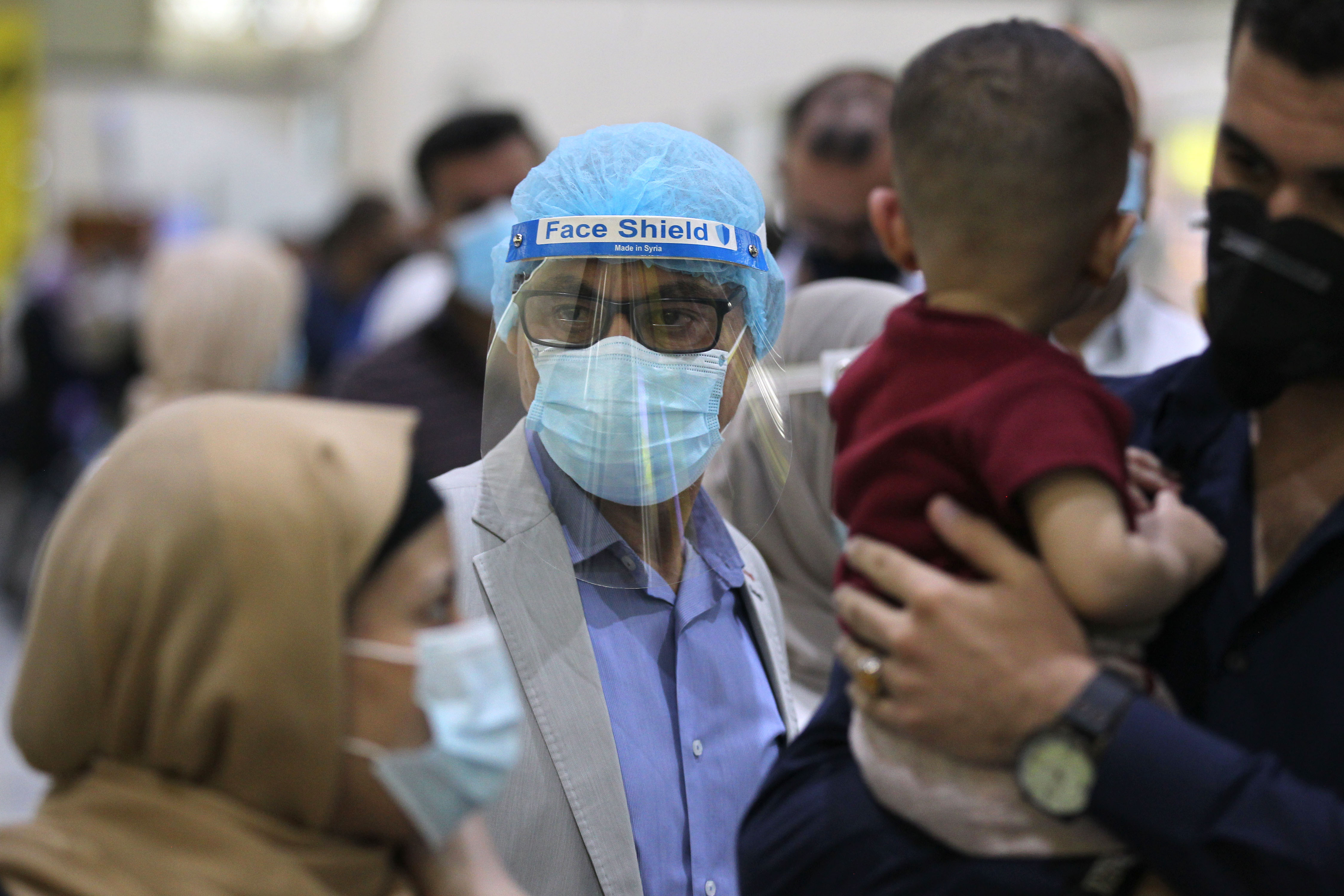 Passengers wearing protective masks wait for flights at the departure hall of Baghdad International Airport, July 23, 2020. (Photo: AFP/Ahmad al-Rubaye)