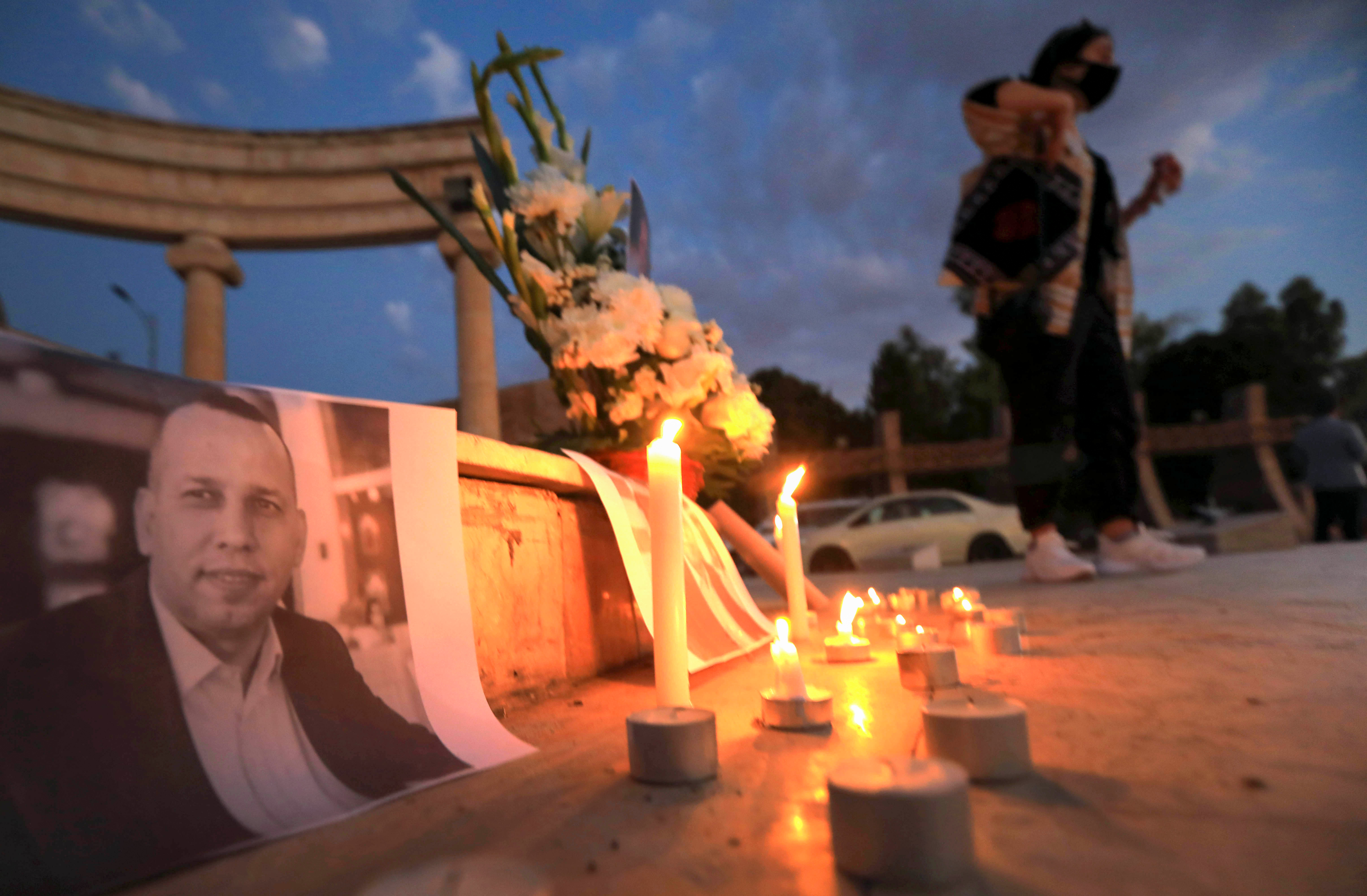 Candles are lit in front of the pictures of prominent security expert Hisham al-Hashimi in the Kurdistan Region's Erbil, July 11, 2020. (Photo: AFP/Safin Hamed)