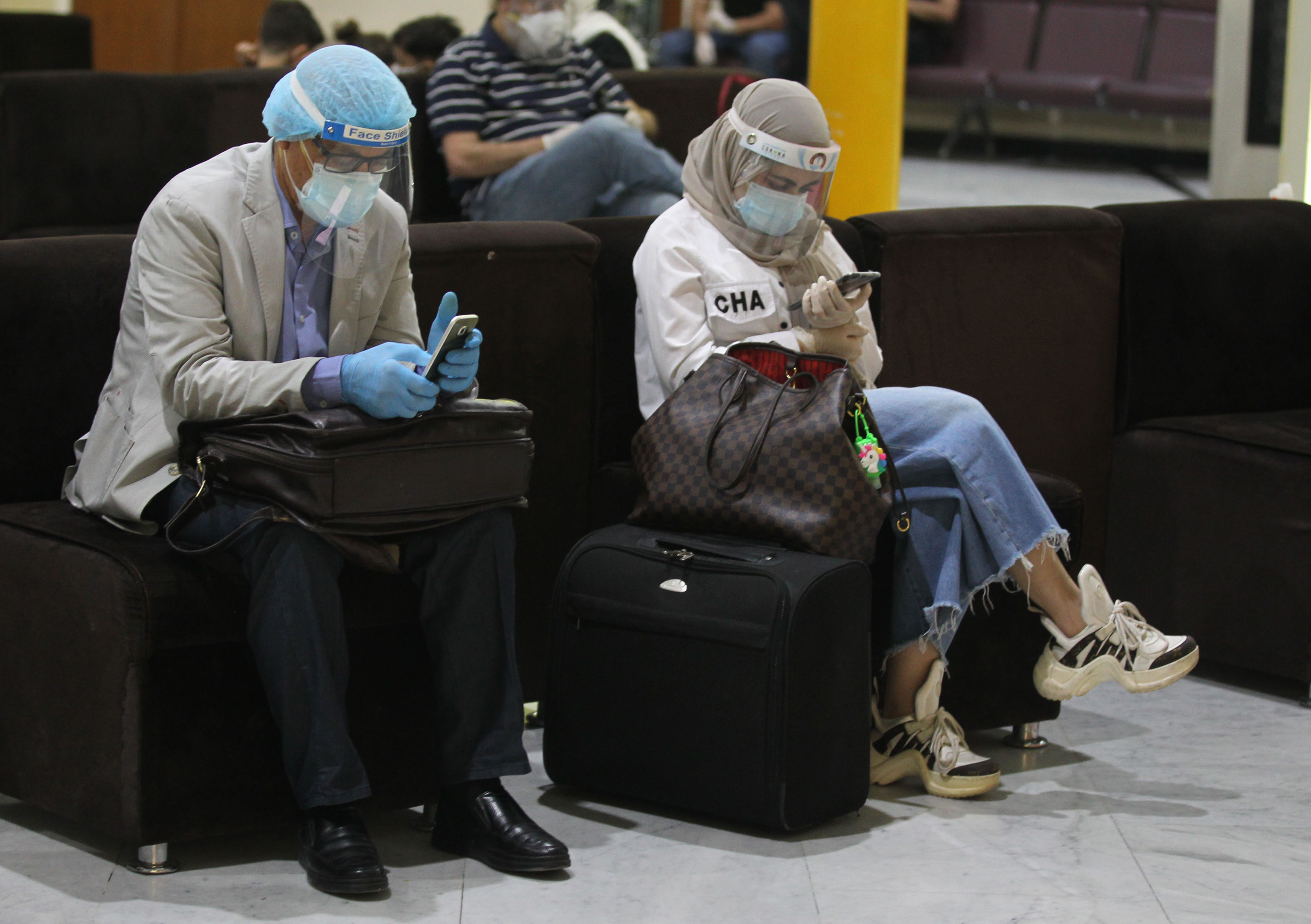 Passengers wearing protective masks wait for flights at the departure hall of Baghdad International Airport, July 23, 2020. (Photo: AFP/Ahmad al-Rubaye)