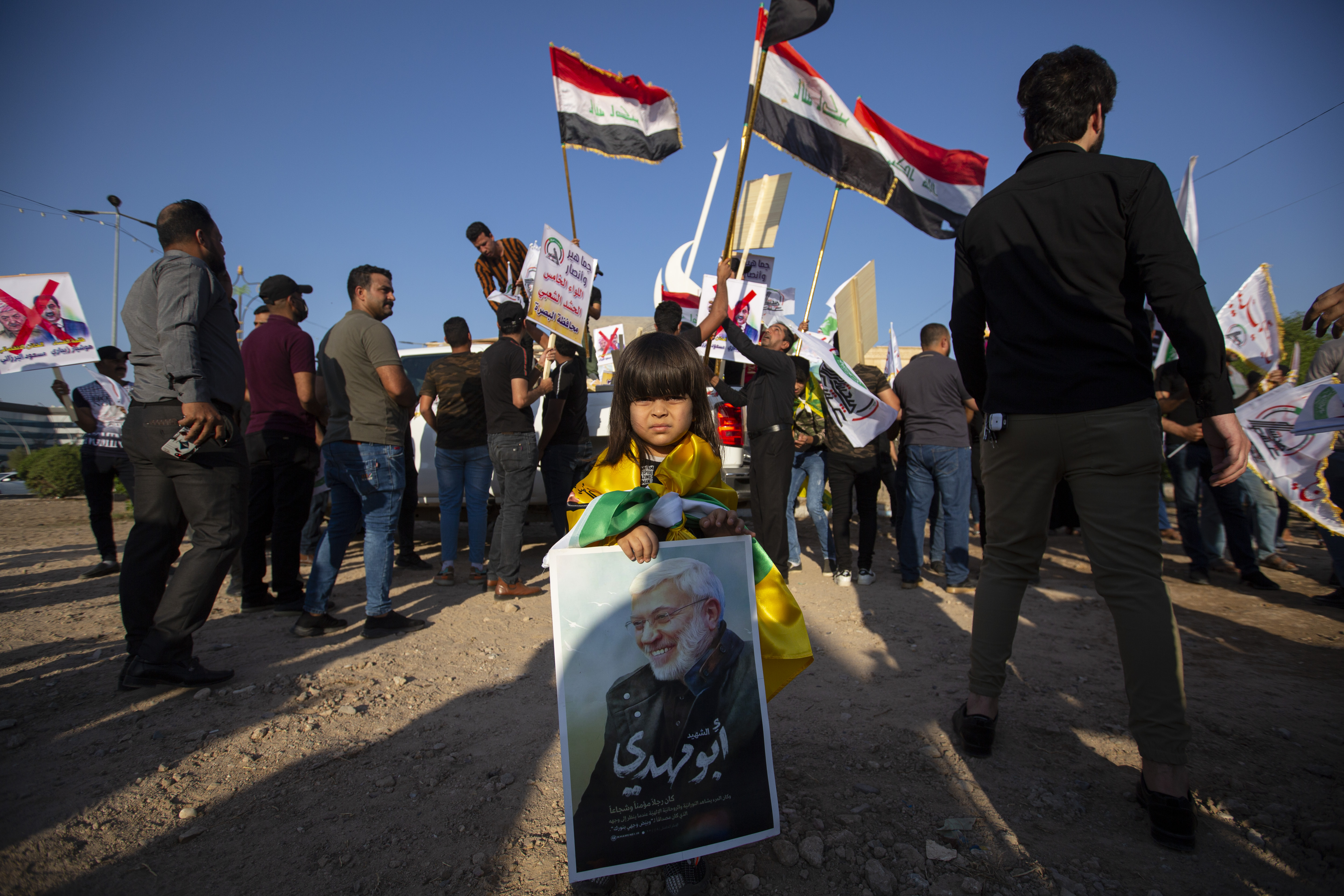 A small girl carries a portrait of slain paramilitary commander Abu Mahdi Al-Muhandis during a protest in the southern Iraqi city of Basra on the same day that militia supporters set fire to the main Baghdad office of the KDP, Oct. 17, 2020. (Photo: AFP/Ahmad al-Rubaye)