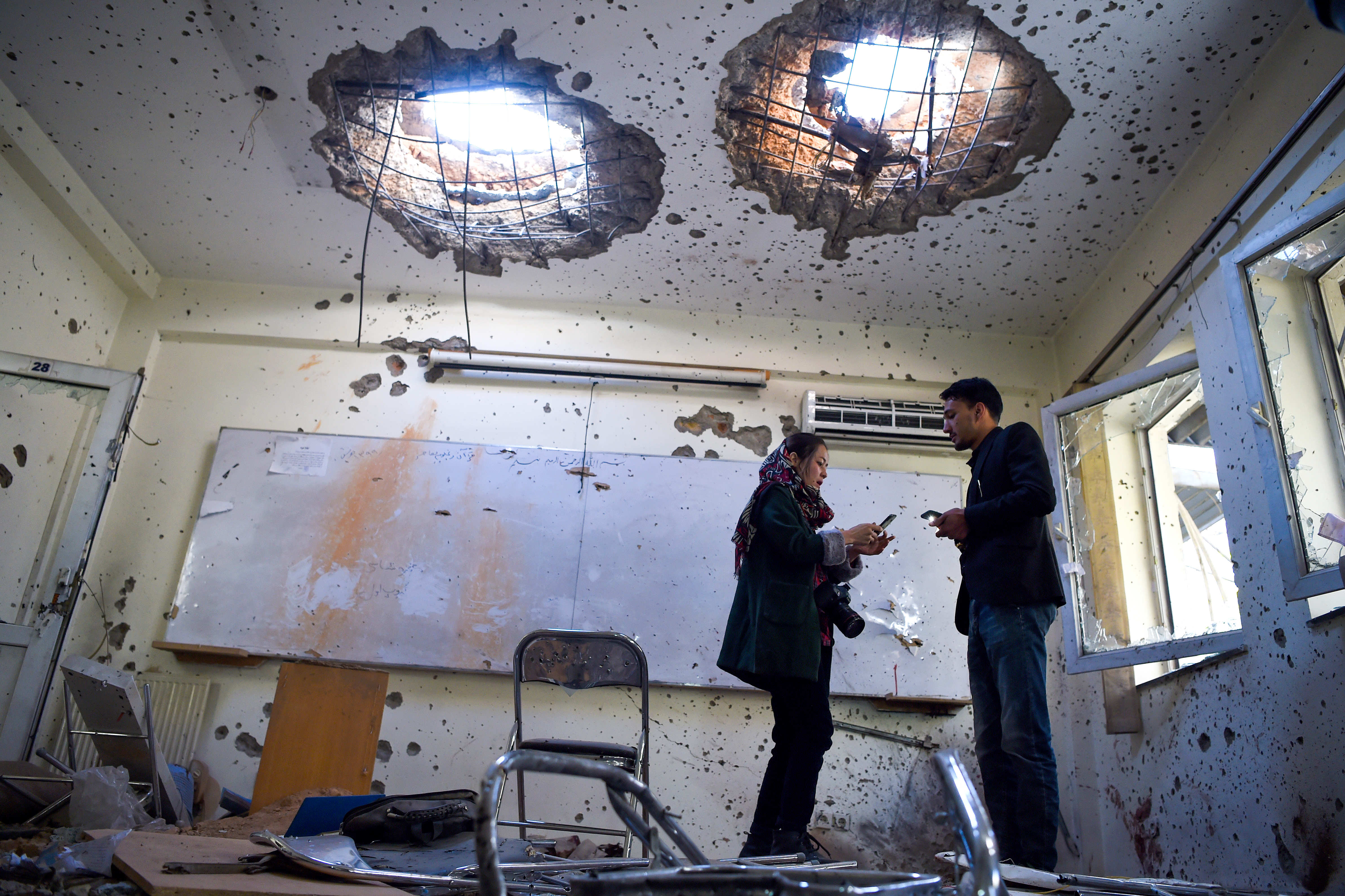 Journalists stand inside a damaged classroom at the National Legal Training center a day after gunmen stormed the university in Kabul, Nov. 3, 2020. (Photo: AFP/Wakil Koshar)