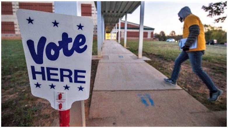 A volunteer with Democracy North Carolina arrives at Waddell Language Academy in Charlotte shortly after polls opened, Nov. 3, 2020. (Photo AFP)
