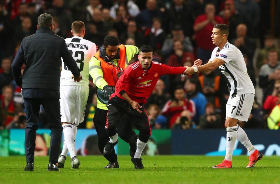 Ronaldo tries to prevent Wsu from being dragged down as match stewards tackle him. (Photo: Reuters)